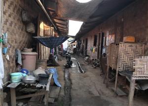 In the passageways between rows of houses at Mai Nai IDP camp, the cramped nature of living quarters is felt. The camp provides IDPs relative safety from the Burma Army as it is close to Myitkyina, which also offers access to employment and schooling.