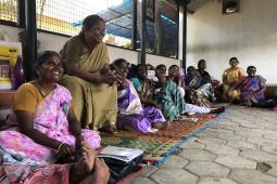 Women representatives of Tamil Nadu Women's Collective sit in a circle, sharing and laughing.