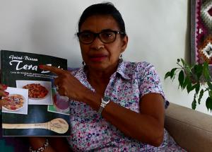 Augusta Henriques avec le livre de recettes de Tiniguena, qui valorise les ingrédients et saveurs traditionnellement guinéens.