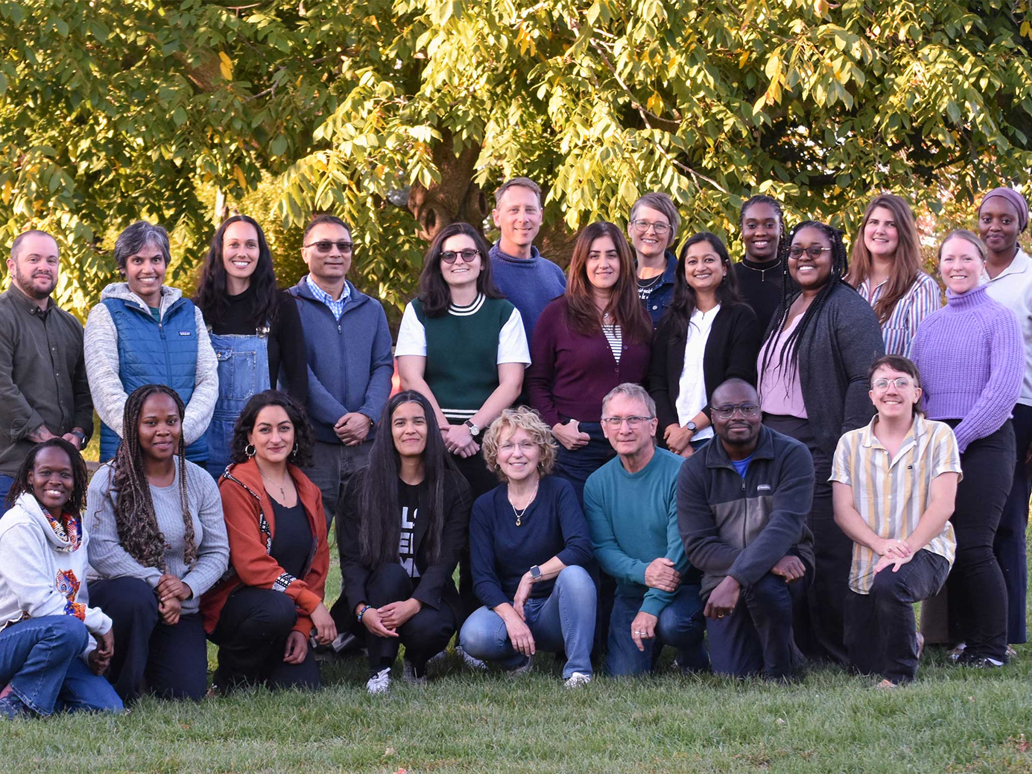 Inter Pares staff members stand together in a group outside in front of a tree.